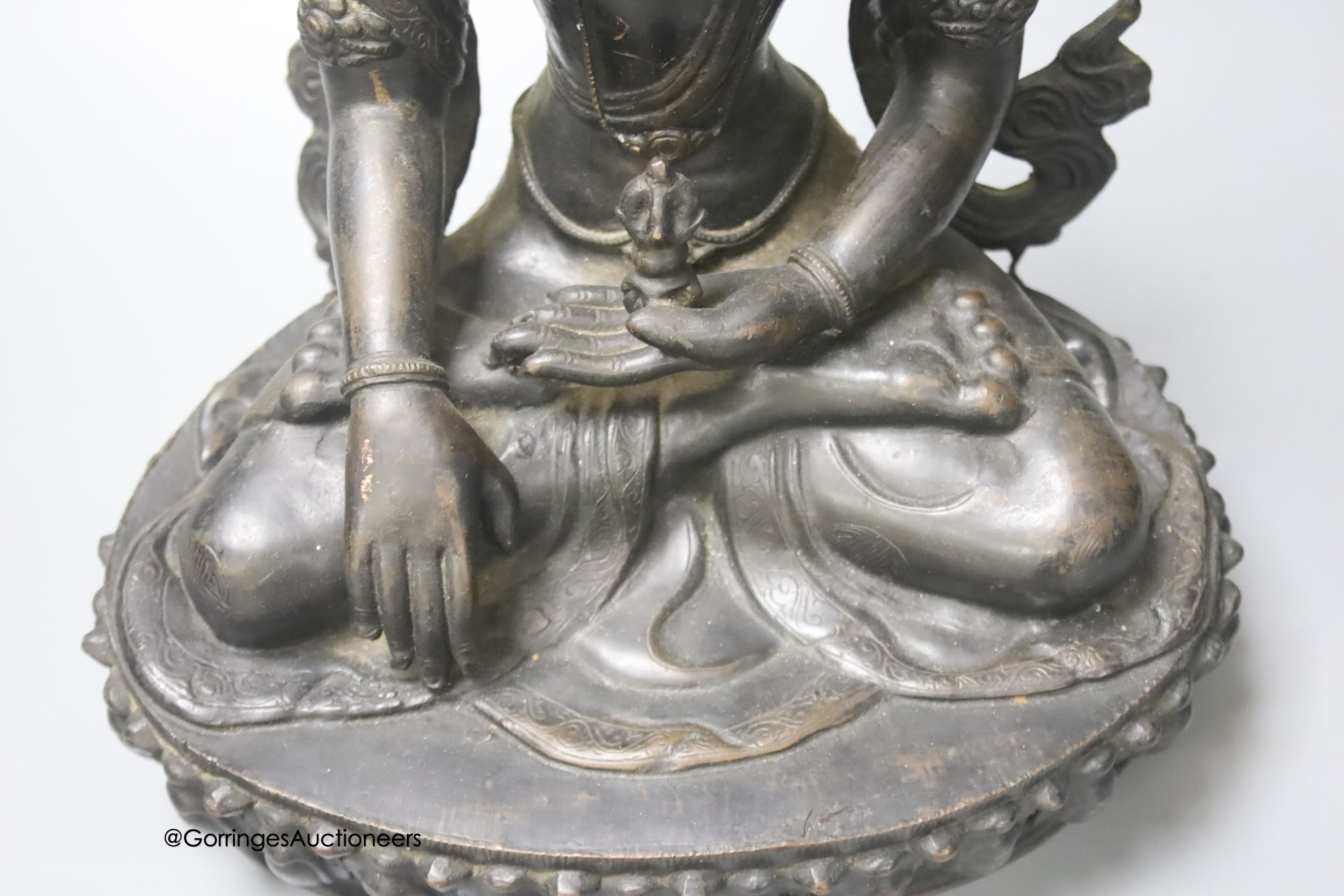 A bronze figure of a Bodhisattva, seated on an oval lotus base, 36cm